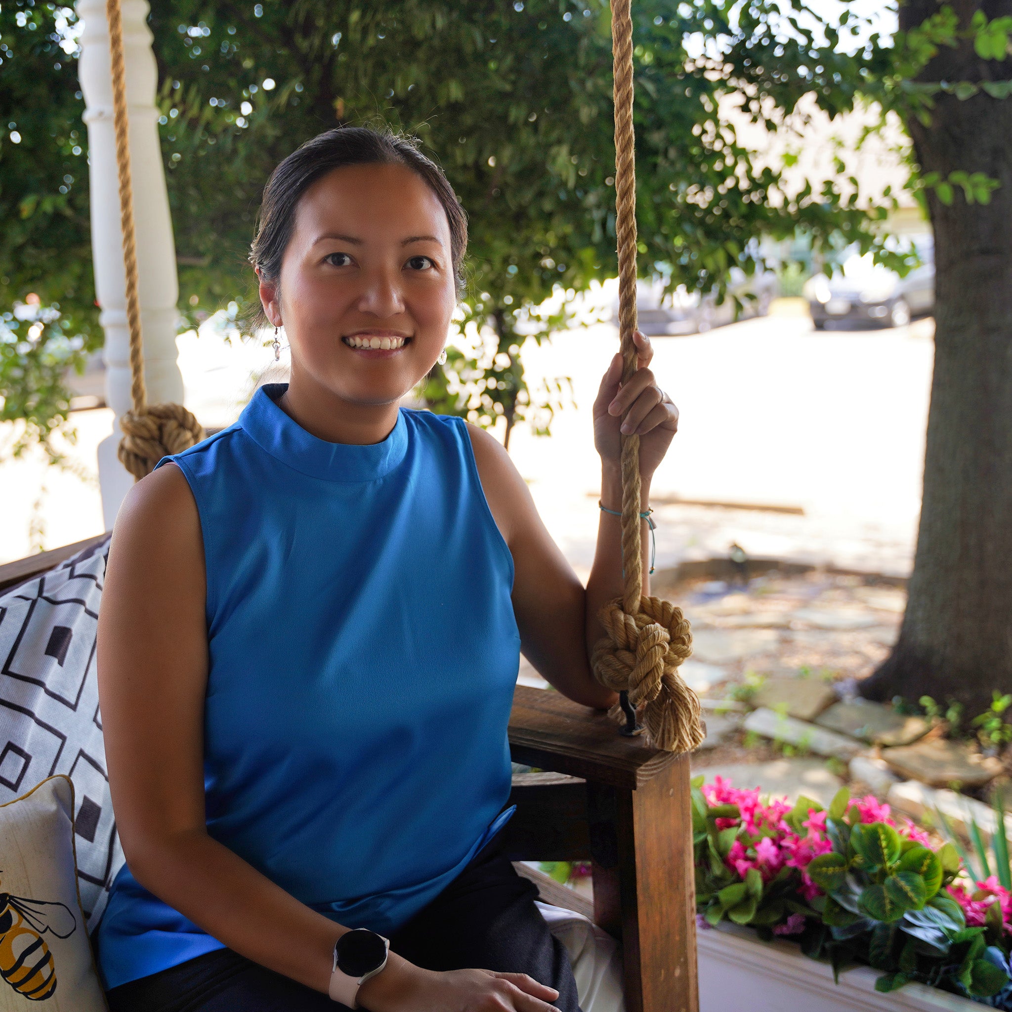 Trang pictured in a swing with beautiful flowers